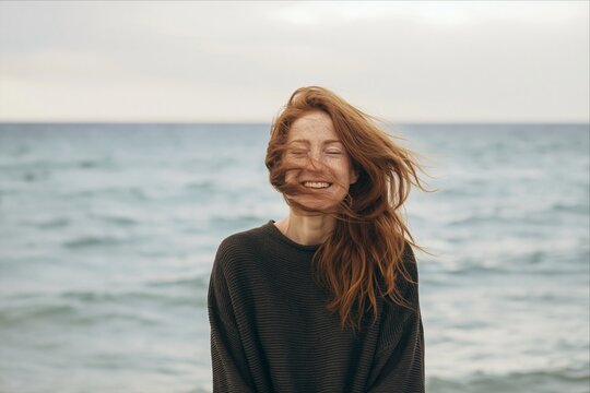 Happy young woman with her hair blowing in the wind