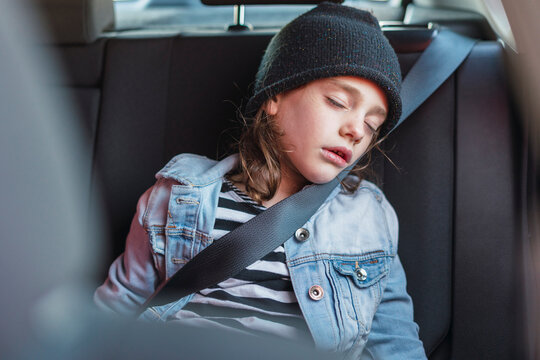 Portrait of sleeping little girl on back seat of a car