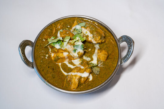 Chicken Saagwala Indian Food served in a traditional balti bowl garnished with cream and fresh hara dhaniya