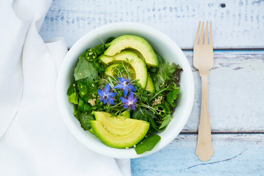 Detox Bowl of different lettuces, vegetables, cress, quinoa, avocado and starflowers
