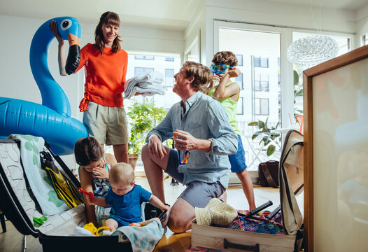 Happy family of five packing for holiday trip