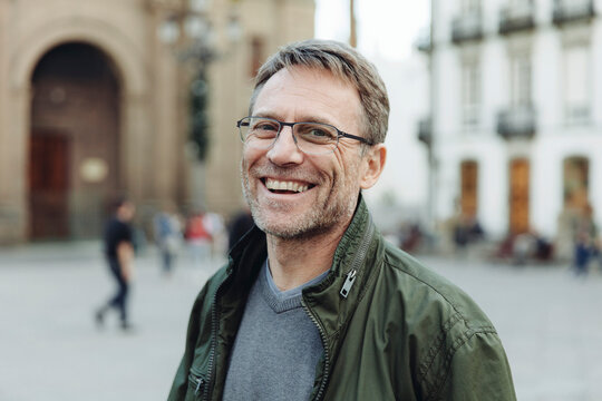 Spain, Canary Islands, Gran Canaria, Las Palmas, portrait of laughing mature man in front of Catedral de Santa Ana