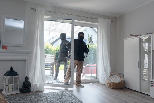 Two burglars entering an one-family house at daytime