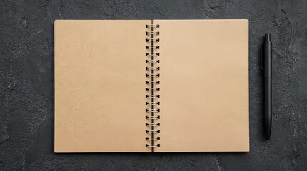 Fototapeta premium Open spiral notebook with pen on dark textured background