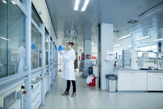 Young female scientist with glass bulb in a chemical lab