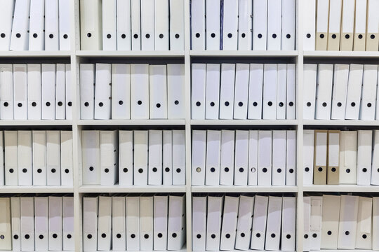 White shelf with rows of white folders