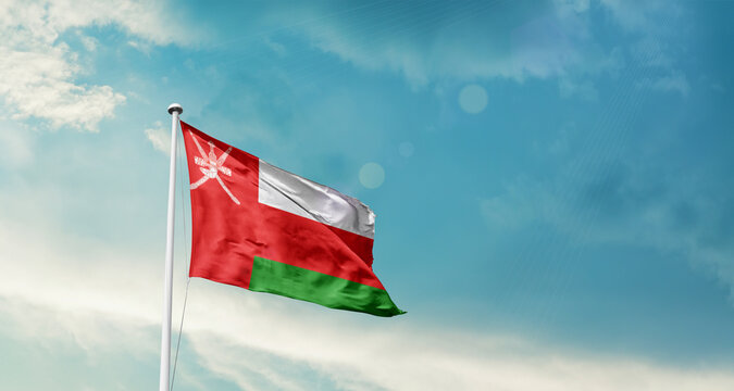 Oman national flag fluttering. The flag blowing in beautiful soft sky. Oman national flag for independence day.