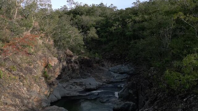 S&atilde;o Miguel River flowing through quartzite canyon in Serra do Segredo, Chapada dos Veadeiros, Goi&aacute;s, Brazil, bordered by native Cerrado woodland and eroded rock formations, ascent tilt down parallax