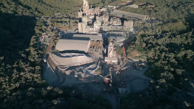 Rare earth mining and mineral processing complex near Bras&iacute;lia, DF, Brazil, with extraction pits, crushing facilities, tailings infrastructure and deforested Cerrado establishing aerial shot