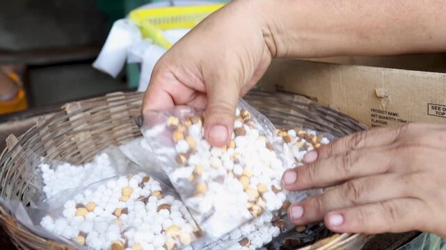 Raw video footage of hands packing sweet prasad packets for Hindu temple devotees during worship and religious rituals in Uttarakhand India.
