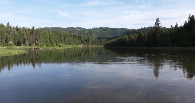 This serene lake reflects the blue sky and distant mountains