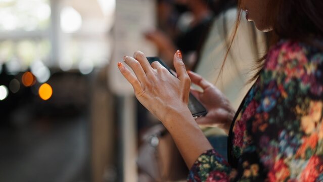 Woman tapping smartphone screen, embracing digital communication in urban setting