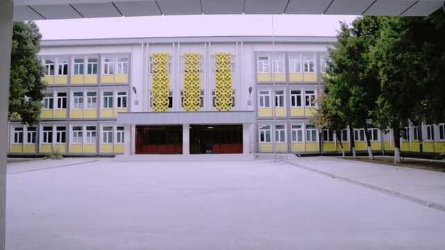 Tashkent, Uzbekistan - 06 06 2025: Modern School Building Exterior with Trees and Empty Courtyard
