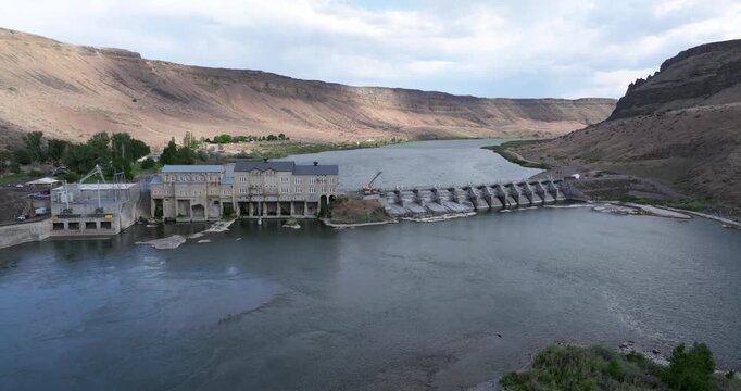 Aerial perspective of a large dam surrounded by arid hills