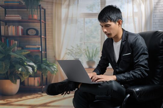 Young Man Working on Laptop in Cozy Indoor Workspace Setting
