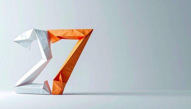 An origami bird and letter Z are on a surface against a wall.