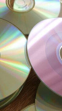 Vertical shot of reflective CDs with colorful light patterns