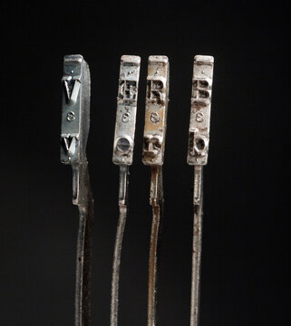 The word VERB with vintage typewriter hammers isolated on black 