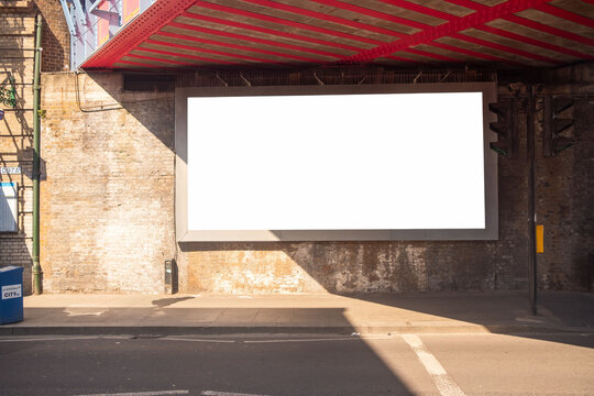 LONDON - Large blank advertising billboard mockup under red railway bridge