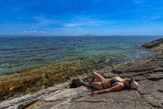 Blonde Woman Sunbathing on Empty &Scaron;i&scaron;an Beach Near Ližnjan, Croatia