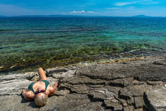 Blonde Woman Sunbathing on Empty &Scaron;i&scaron;an Beach Near Ližnjan, Croatia
