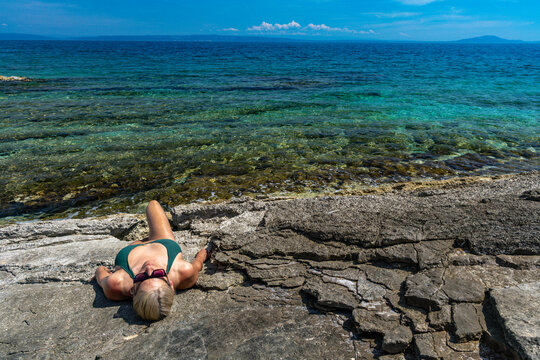 Blonde Woman Sunbathing on Empty &Scaron;i&scaron;an Beach Near Ližnjan, Croatia