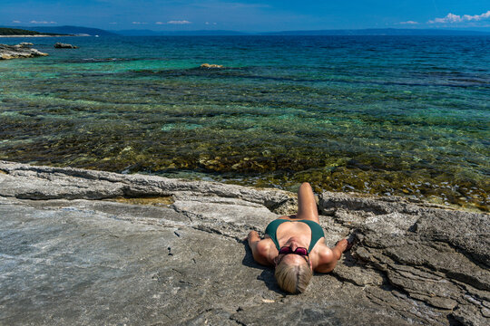 Blonde Woman Sunbathing on Empty &Scaron;i&scaron;an Beach Near Ližnjan, Croatia