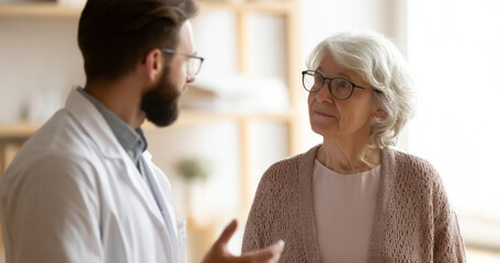 Fototapeta premium Doctor consulting elderly woman in clinic