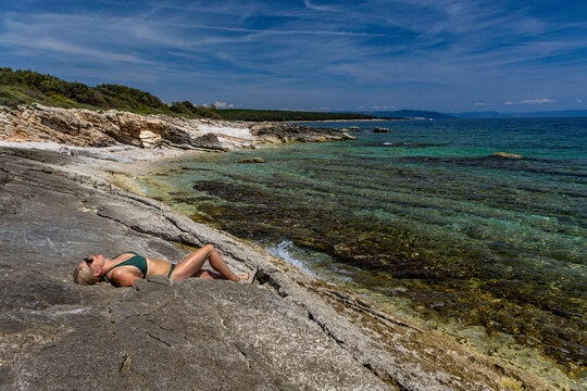 Blonde Woman Sunbathing on Empty &Scaron;i&scaron;an Beach Near Ližnjan, Croatia