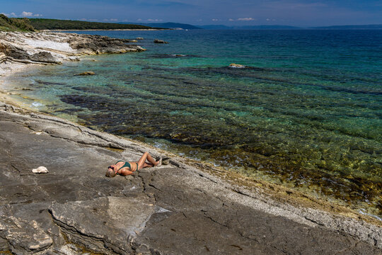 Blonde Woman Sunbathing on Empty &Scaron;i&scaron;an Beach Near Ližnjan, Croatia