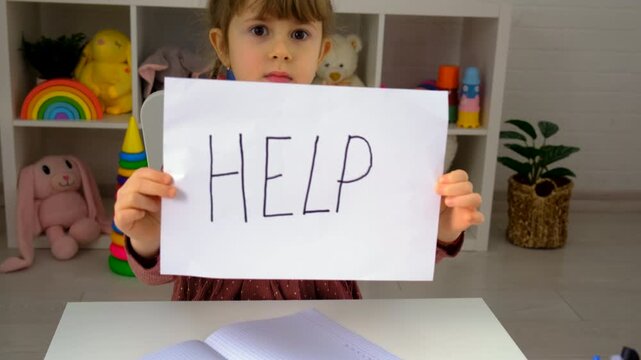 The child is doing homework at home, please help. Selective focus.