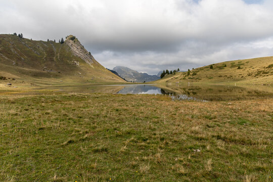 Mirror reflection on Lake Roy with cloudy sky in the Chablais massif, Haute-Savoie, French Alps