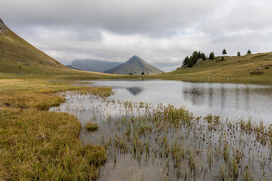 Mirror reflection on Lake Roy with cloudy sky in the Chablais massif, Haute-Savoie, French Alps