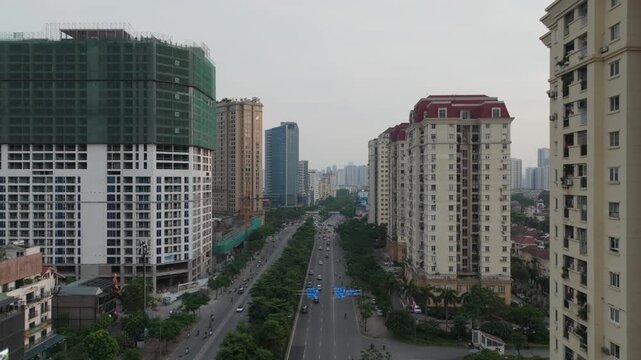 Aerial view of Me Tri Boulevard in Hanoi with residential towers, construction sites, and light traffic during an overcast afternoon.