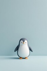 Obraz premium A Charming Cartoon Penguin Stands Alone Against a Serene Light Blue Background