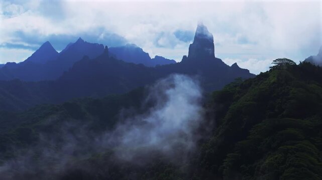 Moorea's dramatic volcanic tall jagged peaks rugged terrain Mount Rotui Mt Toheia French Polynesia aerial drone sunny morning blue sky low clouds fog parallax right Belvedere Lookout Cooks Opunohu Bay