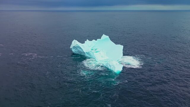 Drone footage of iceberg in rough open ocean swell with whitecaps off Newfoundland coast