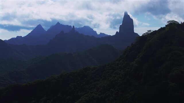 Moorea's dramatic volcanic tall jagged peaks rugged terrain Mount Rotui Mt Toheia French Polynesia aerial drone Belvedere Lookout Cooks Opunohu Bay sunny morning blue sky low clouds fog upwards