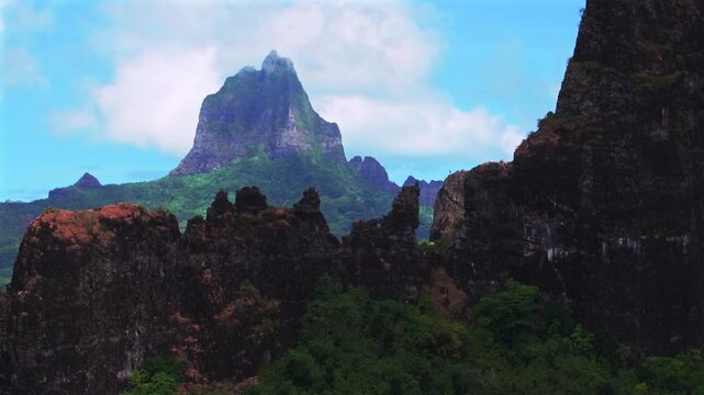 Moorea's dramatic volcanic tall jagged peaks rugged terrain Mount Rotui Mt Toheia French Polynesia aerial drone Belvedere Lookout CooksOpunohu Bay sunny morning blue sky clouds low fog upwards reveal