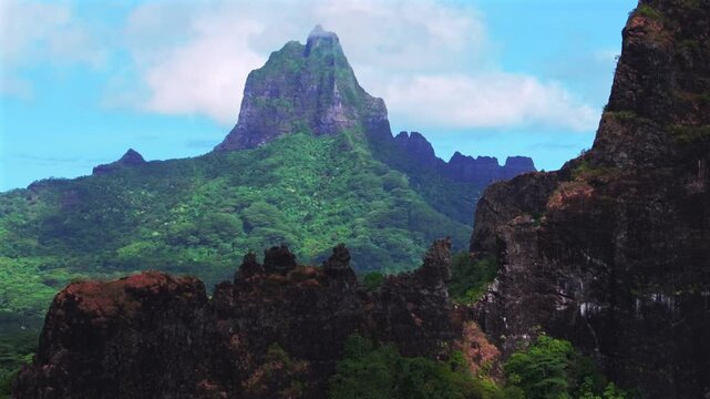 Moorea's dramatic volcanic tall jagged peaks rugged terrain Mount Rotui Mt Toheia French Polynesia aerial drone Belvedere Lookout Cooks Opunohu Bay sunny morning blue sky clouds circle right parallax