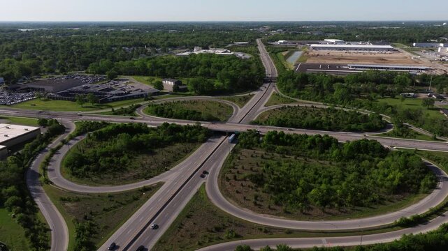 Wide aerial approach above interstate cloverleaf interchange and road network, drone