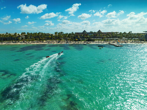 Aerial view of a luxury tropical beach resort and speed boat towing an inflatable tube in Punta Cana Dominican Republic