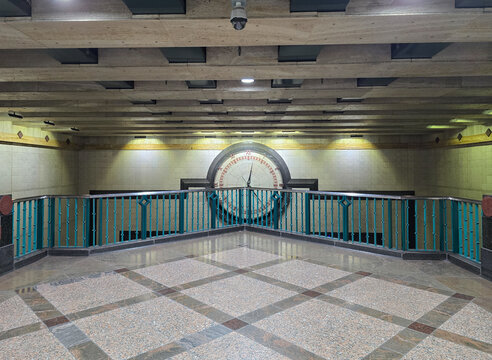 Symmetrical transit station interior with large clock and modern architecture