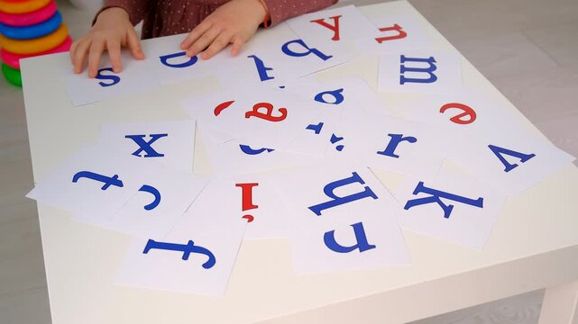 The child learns English letters. Selective focus.