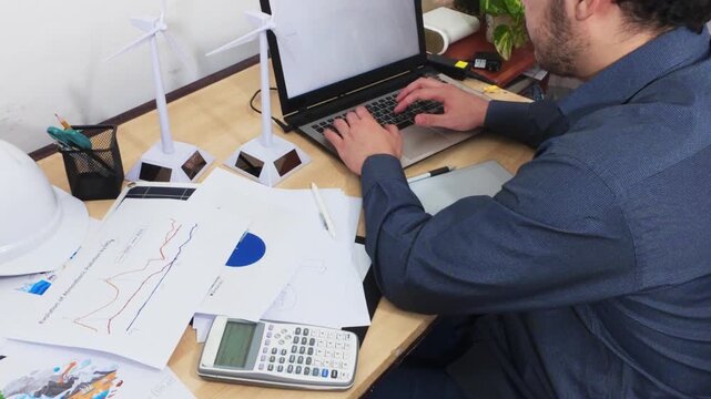 Analyst Performing Data Entry on a Laptop for a Green Project.