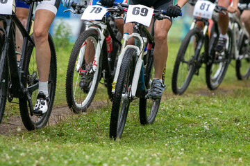 Fototapeta premium Group mountain bike racers participating in cross-country race