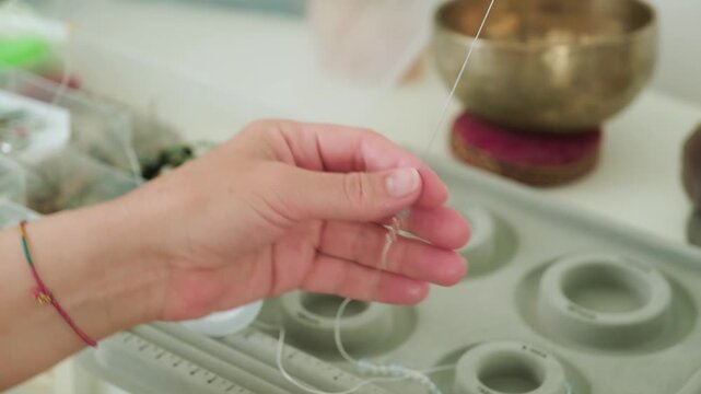Close-up of hands of a woman artisan creating natural stone bracelets
