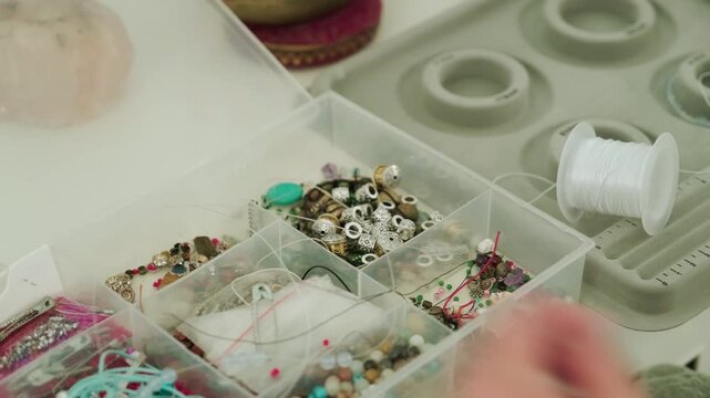 Close-up of hands of a woman artisan creating natural stone bracelets