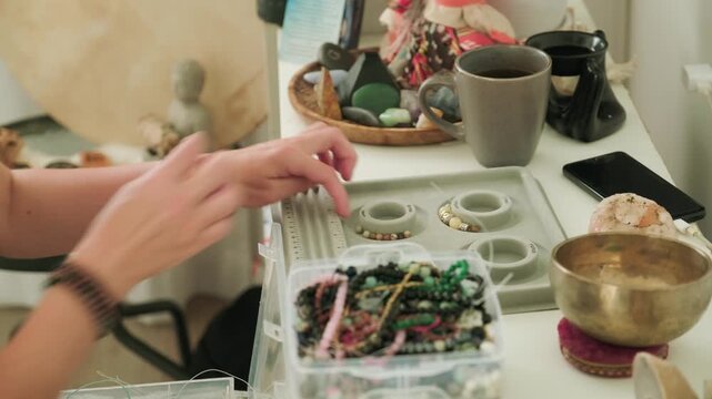 Close-up of hands of a woman artisan creating natural stone bracelets