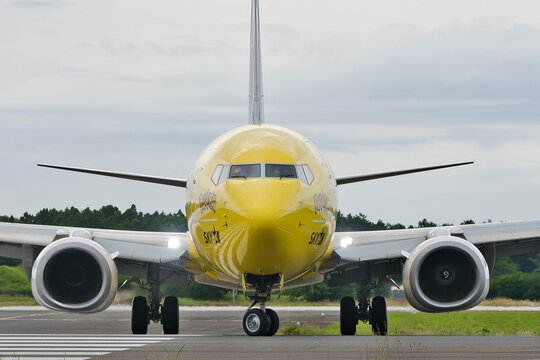 Ibaraki Airport, Japan - June 11, 2022: Skymark Airlines Boeing 737-800 (JA73AB) "Pikachu Jet BC1" Pokemon special livery taxiing head-on with landing lights illuminated, pilot waving